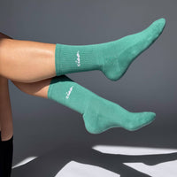 Teal socks with white branding on a gray background